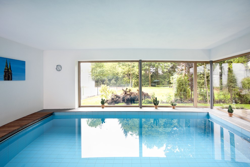 Foto de piscina contemporánea de tamaño medio rectangular y interior con entablado