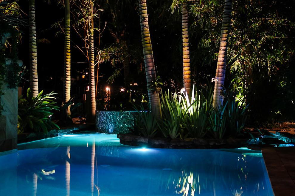 Diseño de piscina con fuente alargada exótica extra grande a medida en patio trasero con adoquines de piedra natural