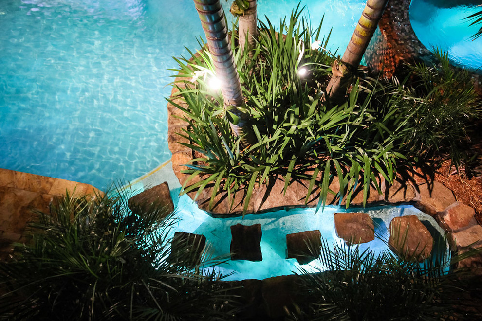 Modelo de piscina con fuente alargada tropical extra grande a medida en patio trasero con adoquines de piedra natural
