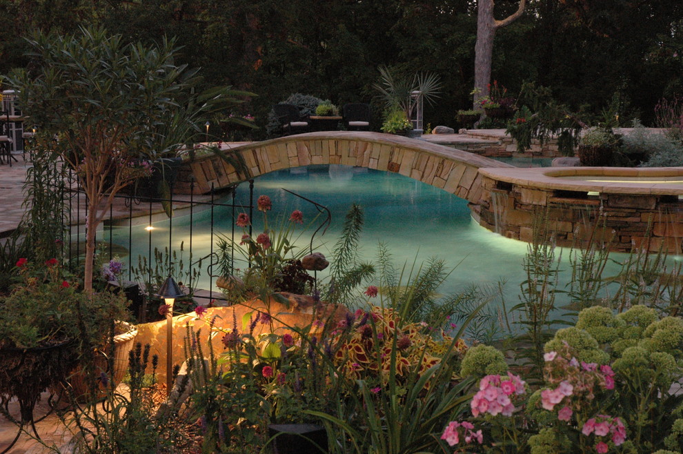 Esempio di una grande piscina naturale eclettica personalizzata dietro casa con pavimentazioni in pietra naturale