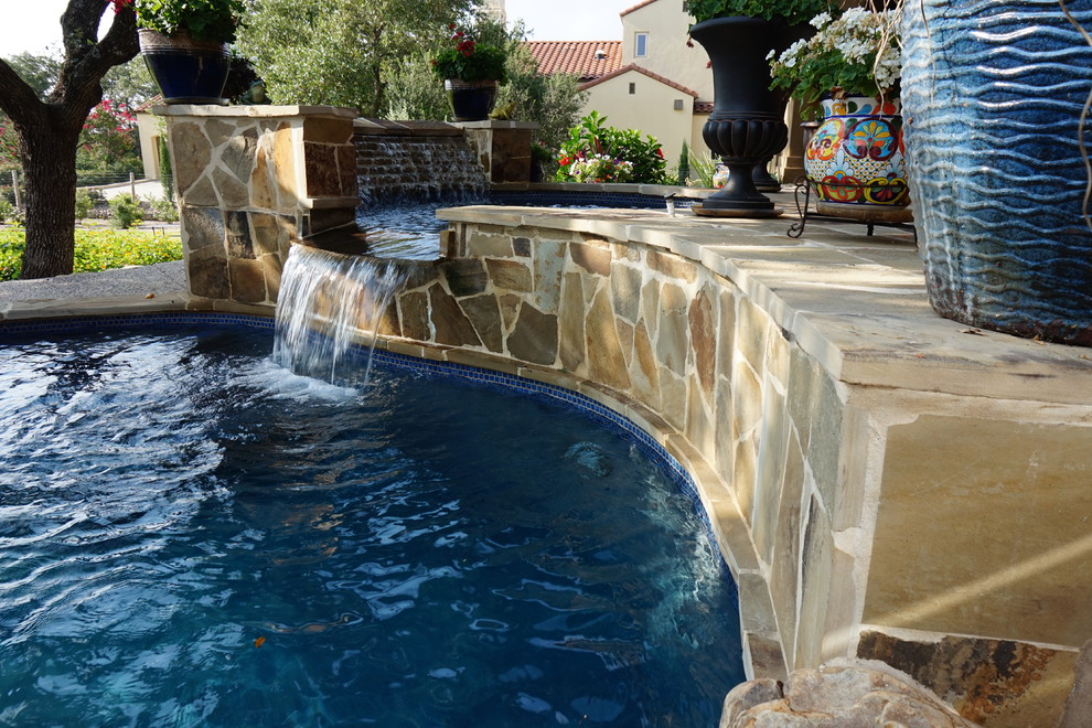 Cette image montre une grande piscine naturelle et arrière chalet en forme de haricot avec un bain bouillonnant et des pavés en pierre naturelle.