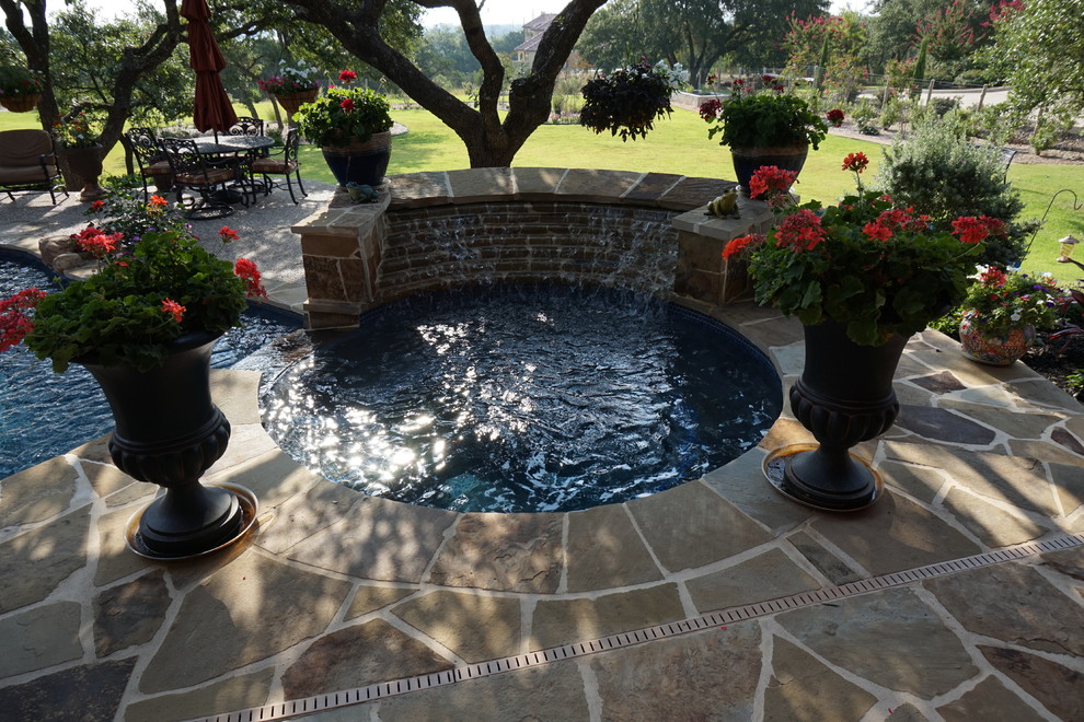 Example of a large mountain style backyard stone and kidney-shaped natural hot tub design in Austin