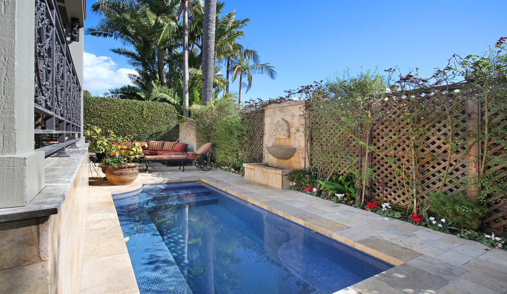 На фото: маленький прямоугольный бассейн на заднем дворе в средиземноморском стиле с фонтаном и покрытием из каменной брусчатки для на участке и в саду