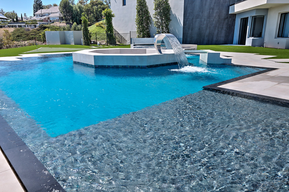 Idee per una grande piscina a sfioro infinito contemporanea personalizzata dietro casa con pavimentazioni in cemento e fontane