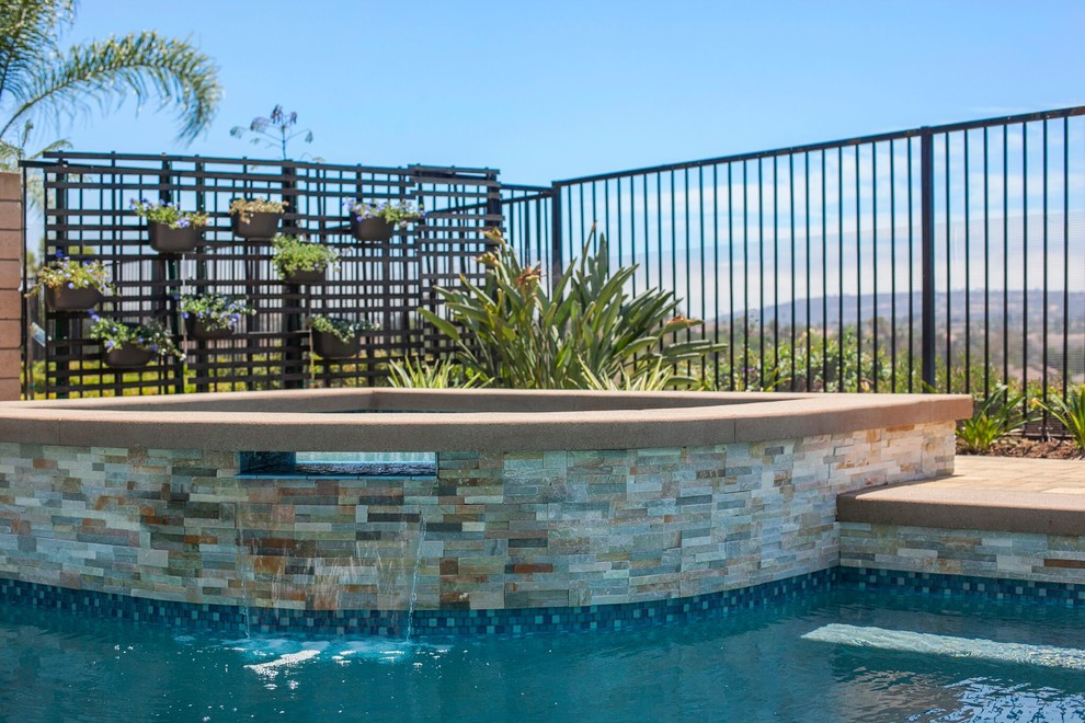 Immagine di una piscina stile marinaro personalizzata dietro casa con una vasca idromassaggio