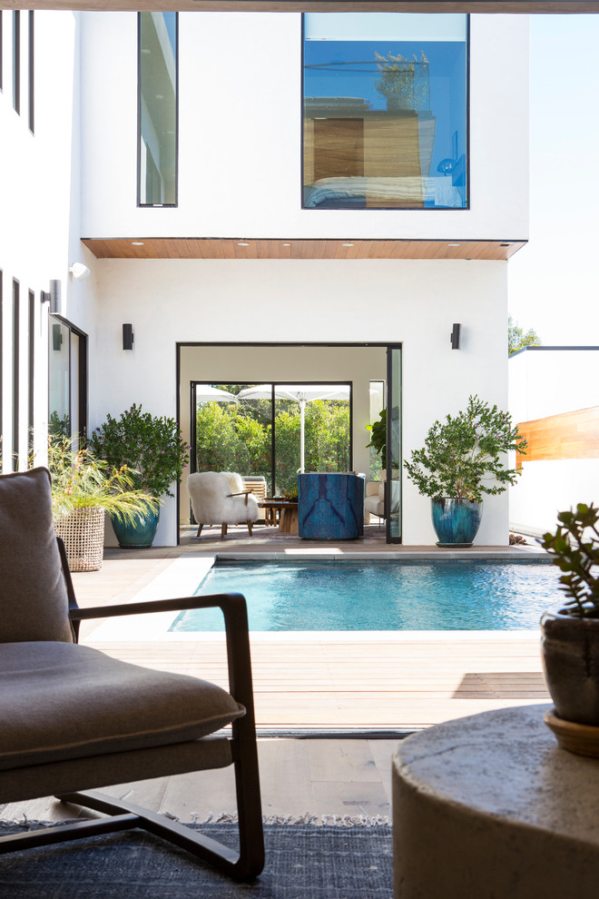Diseño de piscina actual de tamaño medio rectangular en patio con entablado