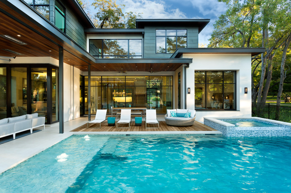 Ispirazione per una piscina a sfioro infinito design dietro casa con una vasca idromassaggio