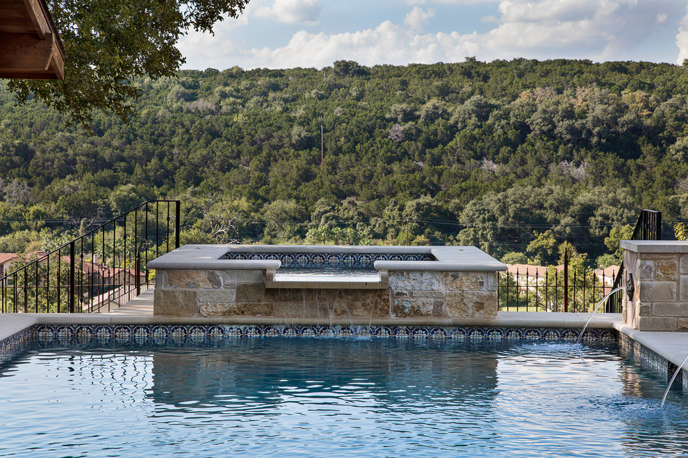 Ejemplo de piscina con fuente elevada de estilo americano pequeña rectangular con suelo de baldosas