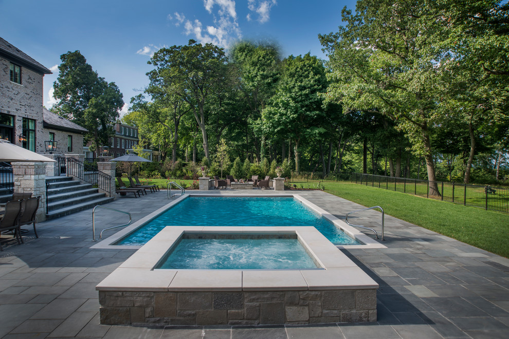 Mid-sized elegant backyard stone and rectangular lap hot tub photo in Chicago