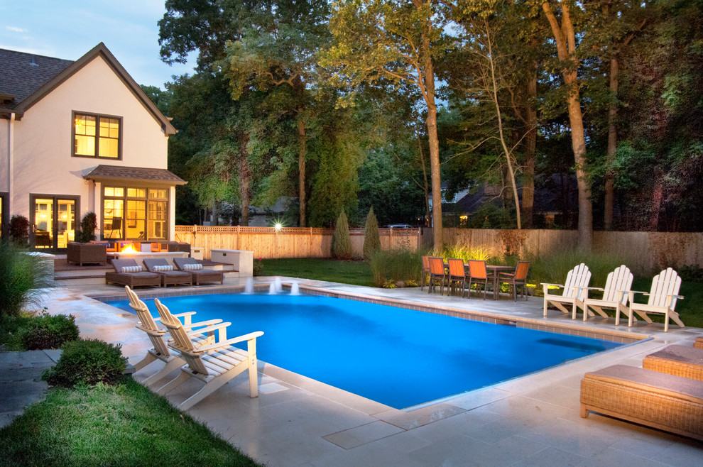 Foto de piscina con fuente alargada clásica pequeña rectangular en patio trasero con adoquines de piedra natural