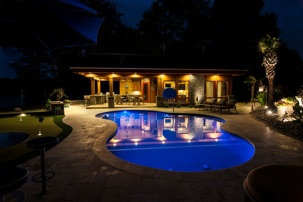 Foto di una grande piscina monocorsia costiera personalizzata dietro casa con una dépendance a bordo piscina e pavimentazioni in pietra naturale