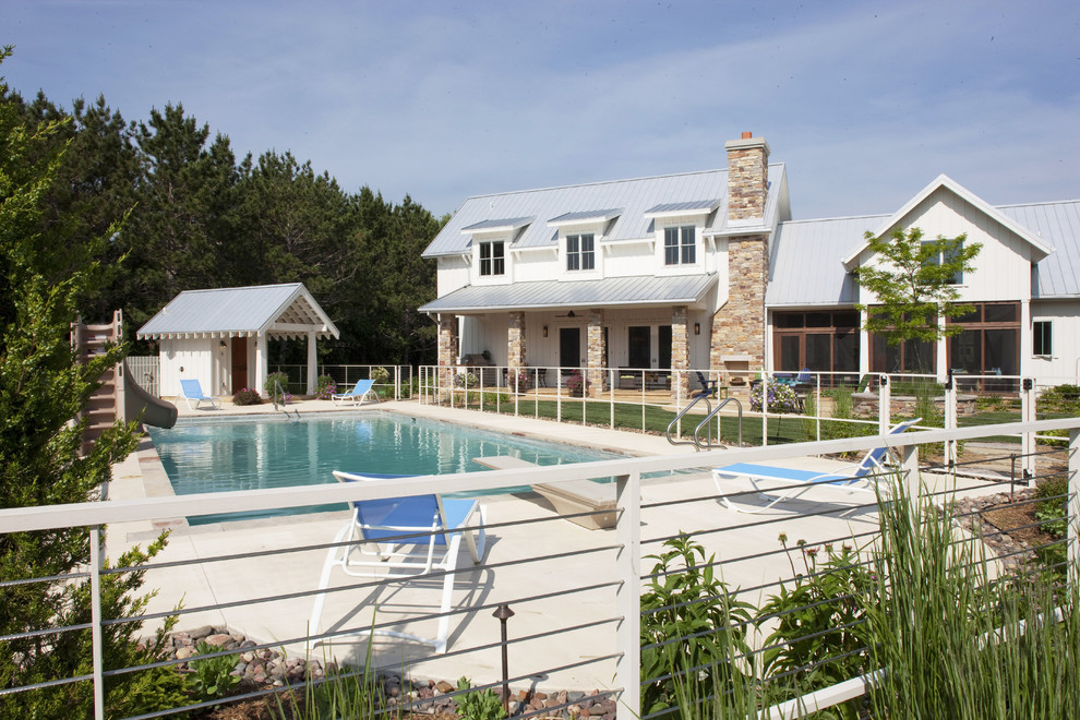 Imagen de piscina con tobogán alargada clásica grande rectangular en patio trasero