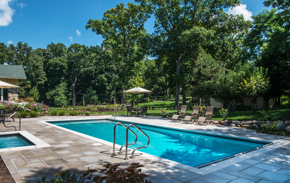 На фото: спортивный, прямоугольный бассейн среднего размера на заднем дворе в морском стиле с джакузи и покрытием из каменной брусчатки с