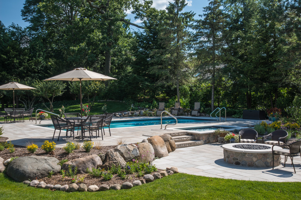 Foto di una piscina monocorsia stile marinaro rettangolare di medie dimensioni e dietro casa con una vasca idromassaggio e pavimentazioni in pietra naturale