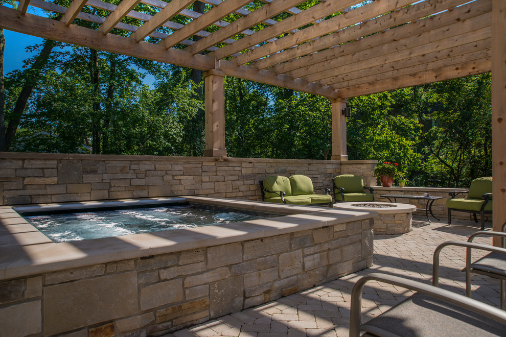 Modelo de piscinas y jacuzzis clásicos pequeños rectangulares en patio trasero con adoquines de hormigón