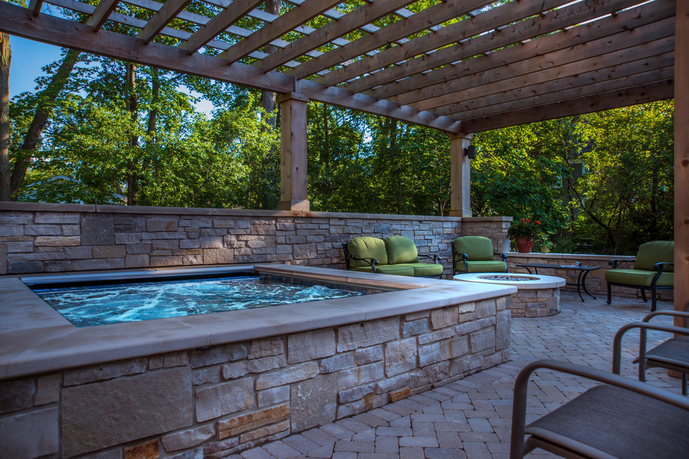 Imagen de piscina clásica pequeña rectangular en patio trasero con adoquines de hormigón