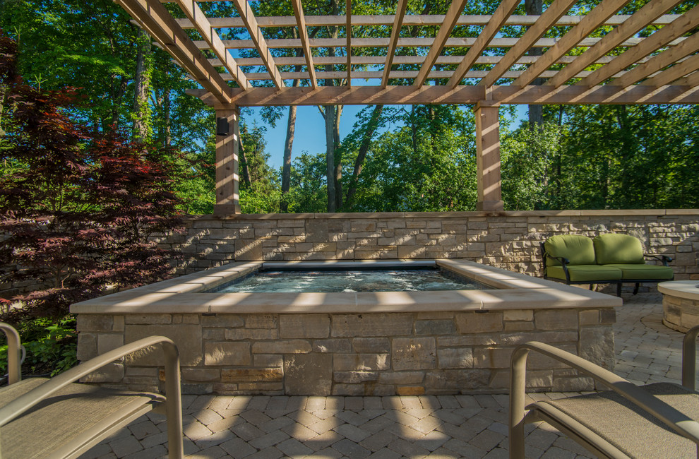 Foto de piscinas y jacuzzis tradicionales pequeños rectangulares en patio trasero con adoquines de hormigón