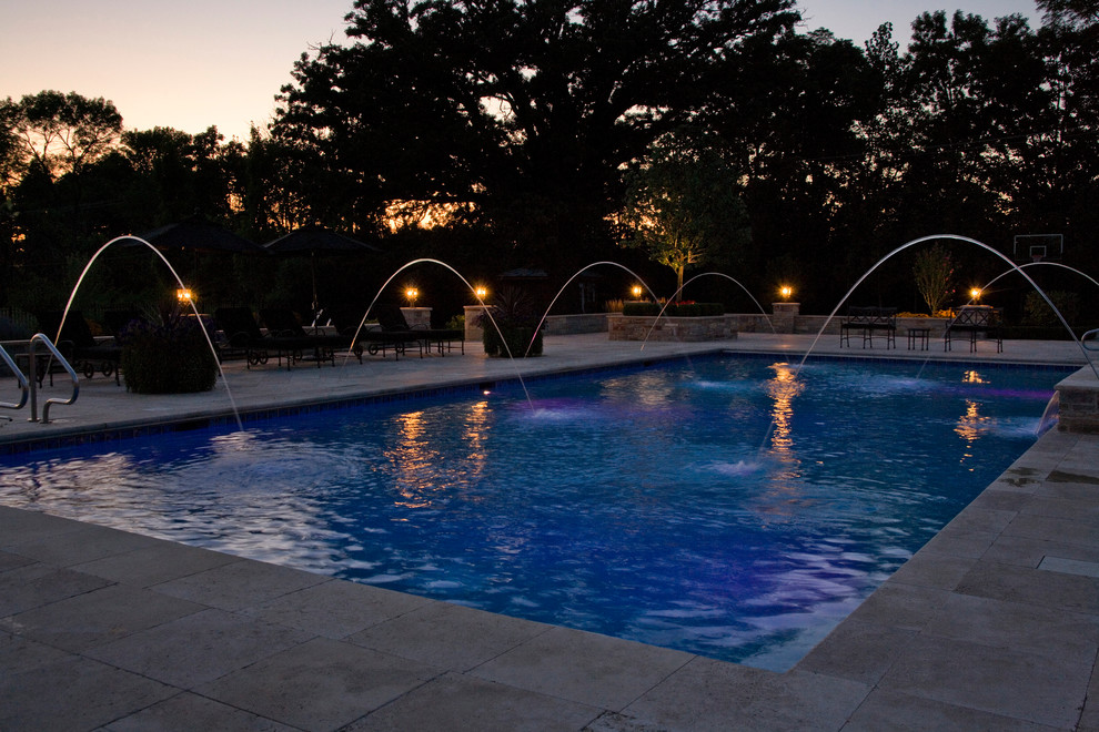 Großer Klassischer Pool hinter dem Haus in rechteckiger Form mit Natursteinplatten in Chicago