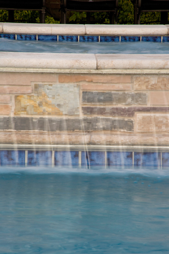 Cette photo montre un grand couloir de nage arrière chic rectangle avec un bain bouillonnant et des pavés en pierre naturelle.