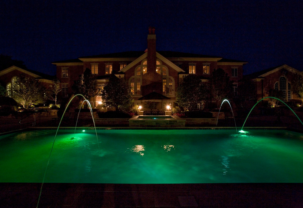 Diseño de piscinas y jacuzzis alargados clásicos grandes rectangulares en patio trasero con adoquines de piedra natural