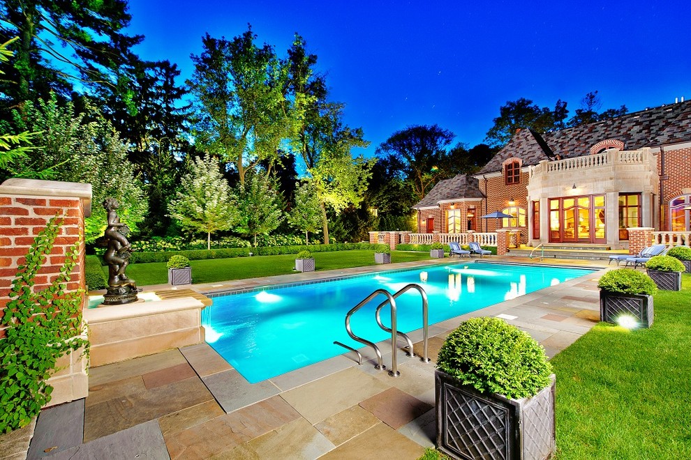 Immagine di una piscina chic rettangolare di medie dimensioni e dietro casa con fontane e pavimentazioni in pietra naturale