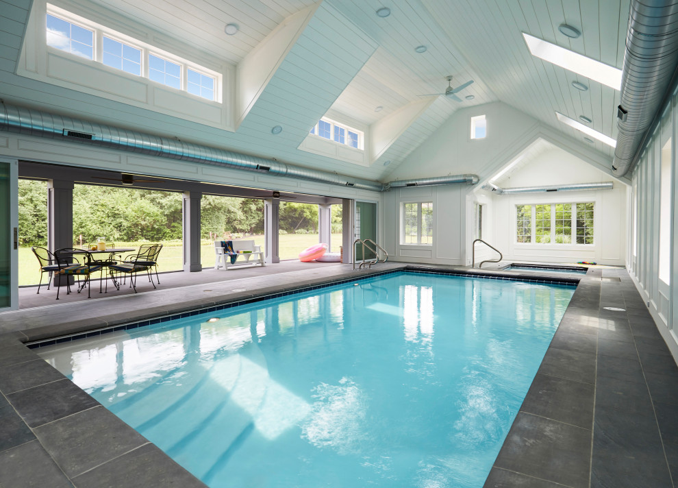Inspiration pour une grande piscine intérieure traditionnelle rectangle avec des solutions pour vis-à-vis et des pavés en pierre naturelle.