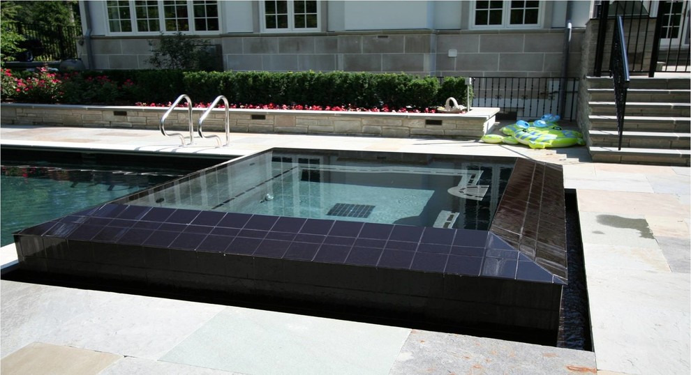 Example of a mid-sized classic backyard stone and rectangular pool design in Chicago