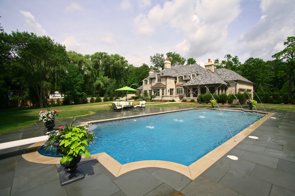 Large elegant backyard concrete paver and rectangular lap pool photo in Chicago