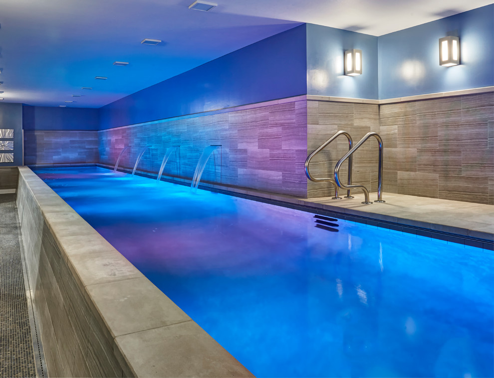 Ispirazione per una grande piscina coperta monocorsia moderna rettangolare con pavimentazioni in pietra naturale e fontane