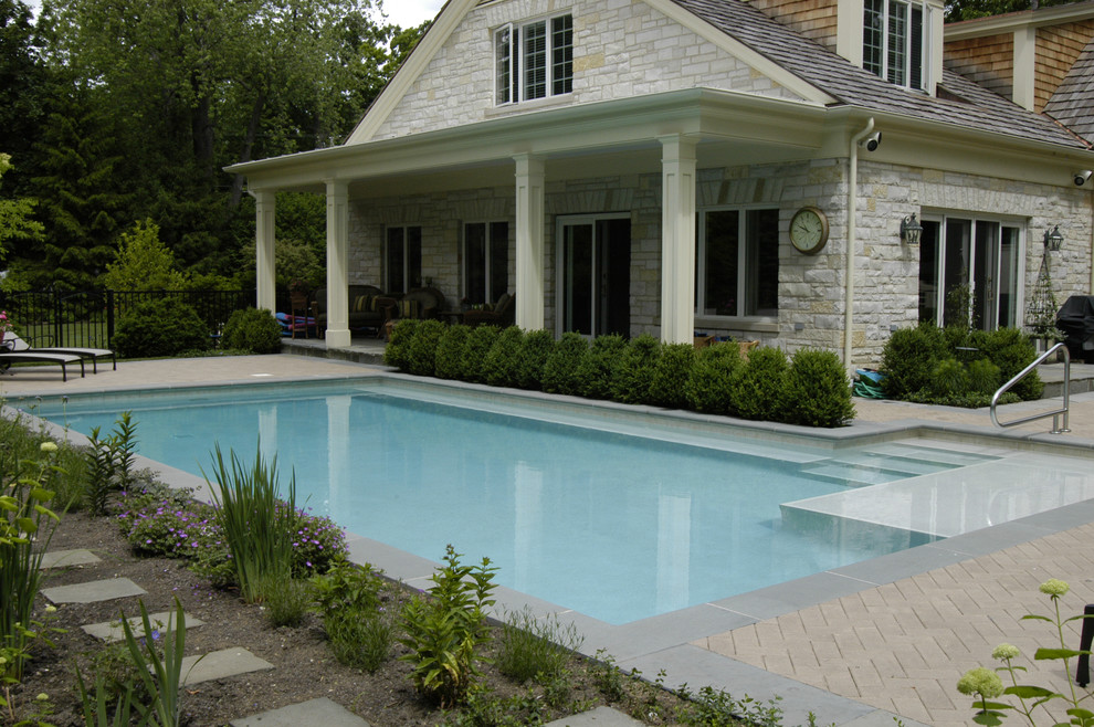 Foto di una piccola piscina monocorsia classica a "L" nel cortile laterale con pavimentazioni in cemento