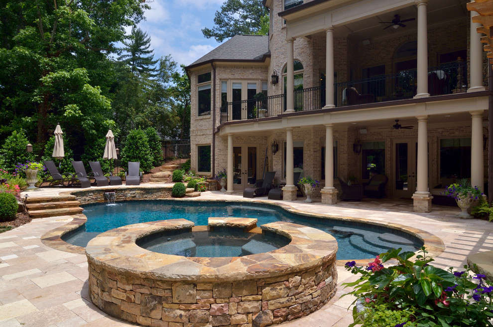 На фото: большой естественный бассейн произвольной формы на заднем дворе в классическом стиле с джакузи и покрытием из каменной брусчатки