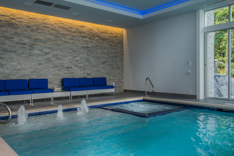 Cette image montre une piscine minimaliste de taille moyenne et rectangle avec un bain bouillonnant et du carrelage.