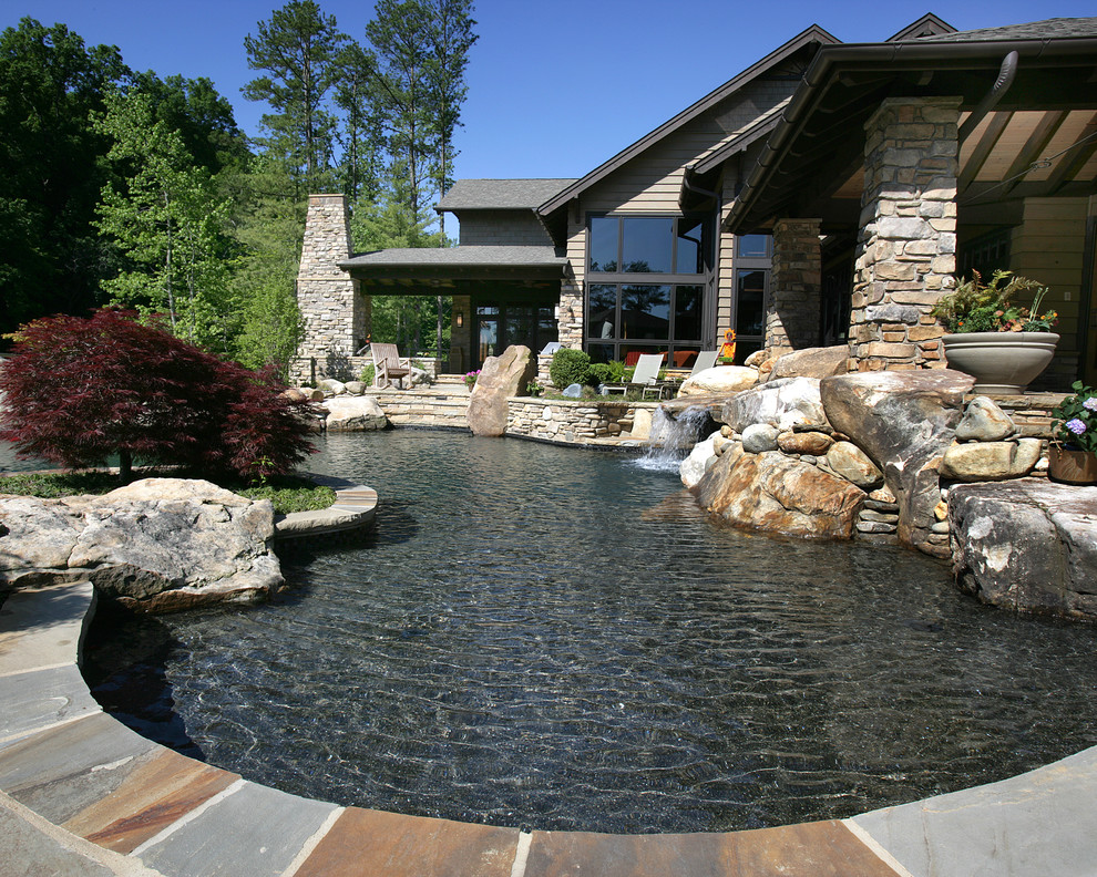 Modelo de piscinas y jacuzzis infinitos clásicos grandes a medida en patio trasero con adoquines de piedra natural