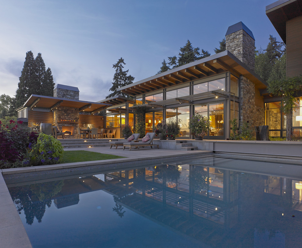 Idee per una grande piscina monocorsia design rettangolare dietro casa con pavimentazioni in cemento