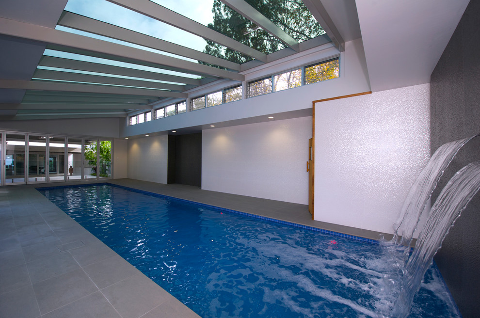 На фото: прямоугольный бассейн среднего размера в доме в современном стиле с фонтаном и покрытием из плитки с