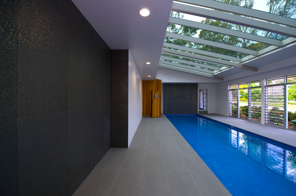 Esempio di una piscina coperta minimal rettangolare di medie dimensioni con fontane e piastrelle