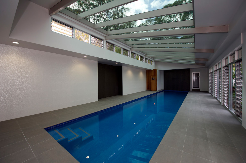 Foto de piscina con fuente actual de tamaño medio rectangular y interior con suelo de baldosas
