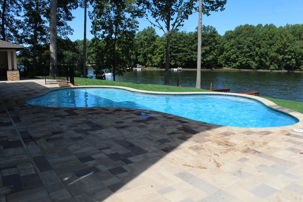 Diseño de casa de la piscina y piscina infinita contemporánea de tamaño medio a medida en patio trasero con adoquines de hormigón