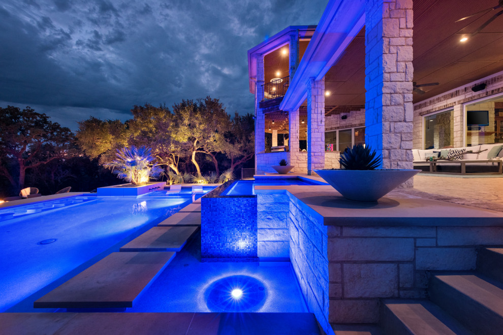 Photo of a large modern back custom shaped hot tub in Austin with concrete slabs.