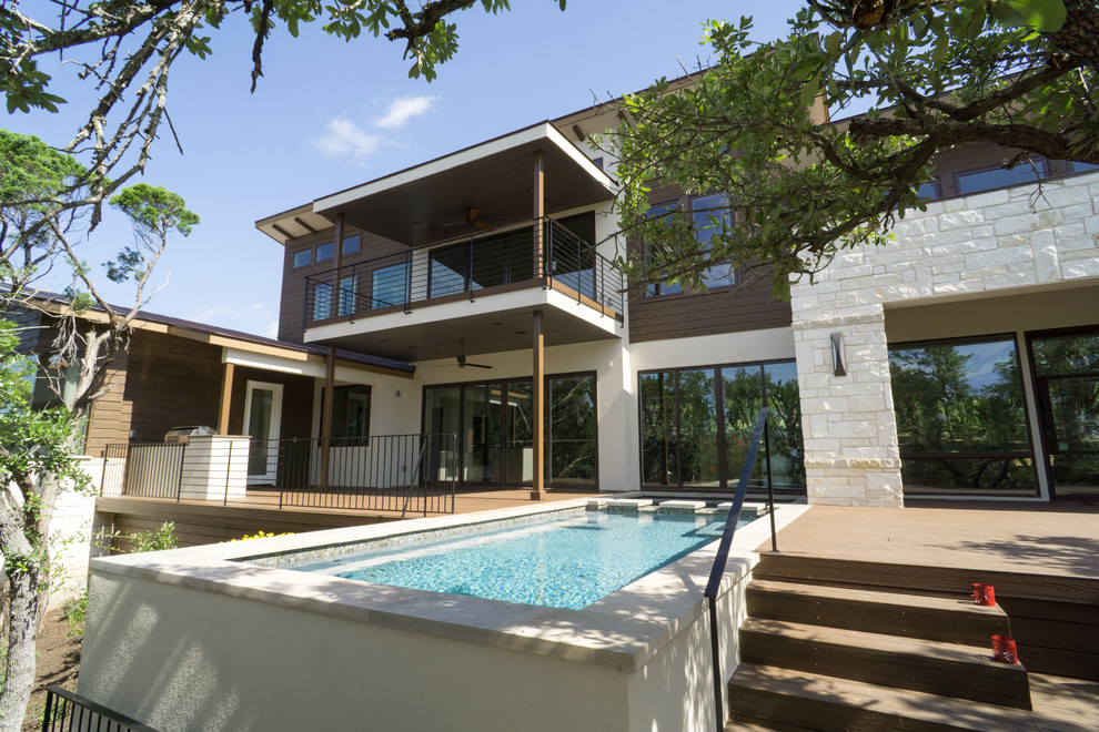 Immagine di una grande piscina monocorsia minimalista rettangolare dietro casa con pedane