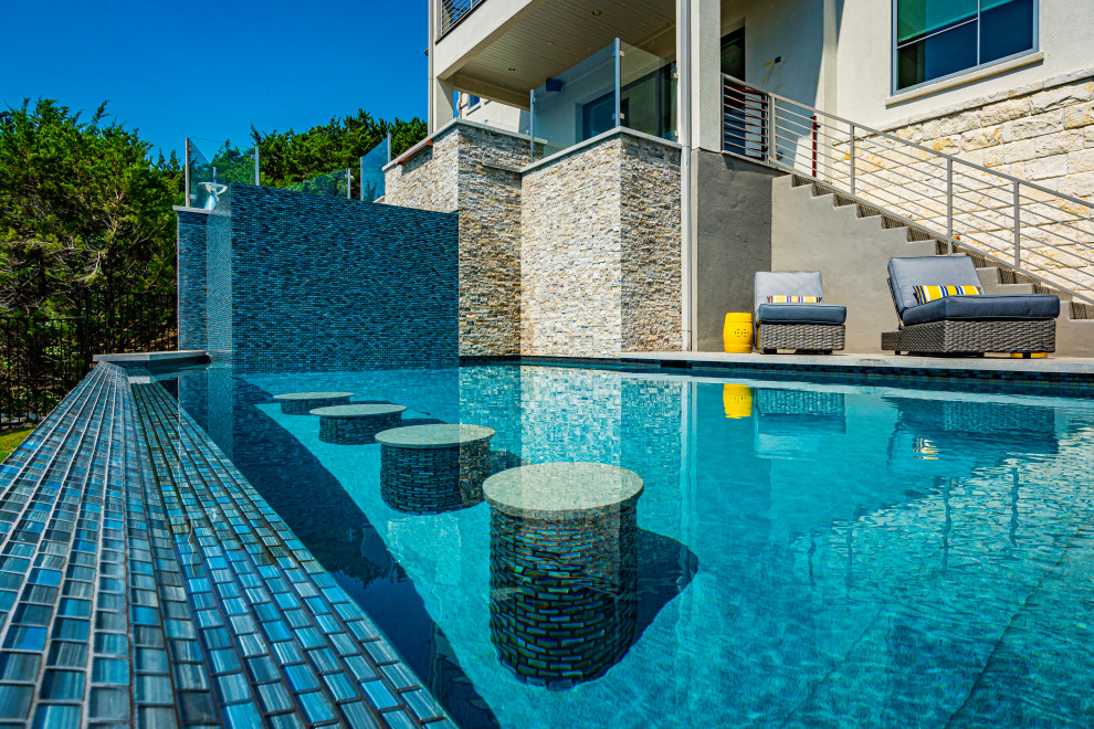 Diseño de piscina actual grande rectangular en patio trasero