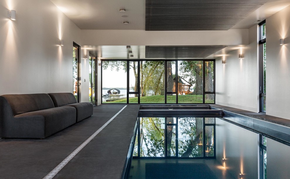 На фото: спортивный, прямоугольный бассейн в доме в современном стиле с