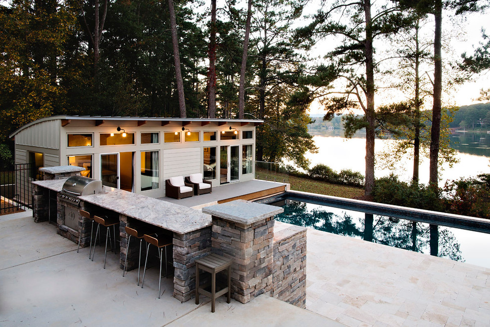 Ispirazione per una grande piscina rettangolare dietro casa con pavimentazioni in pietra naturale