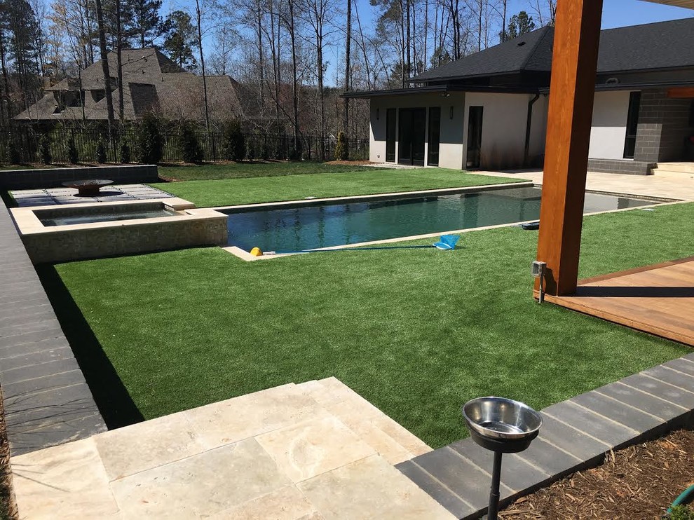 Großer Moderner Pool hinter dem Haus in rechteckiger Form mit Natursteinplatten in Charlotte