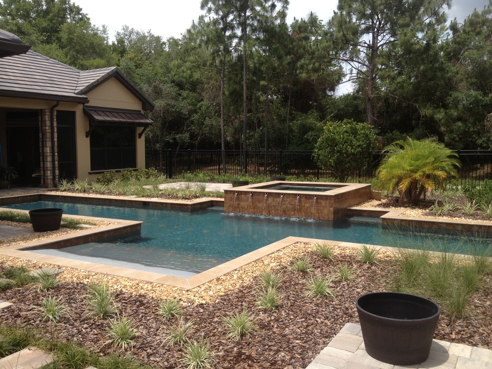 Foto de piscina alargada rústica grande rectangular en patio trasero con gravilla