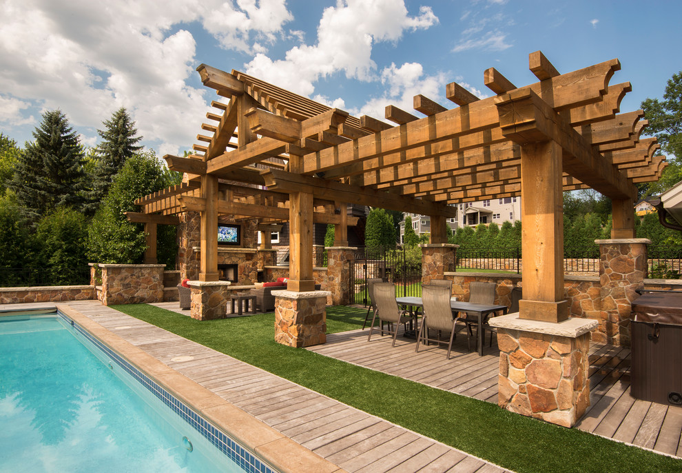 Idée de décoration pour une très grande piscine arrière tradition rectangle avec une terrasse en bois.