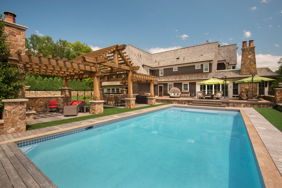 Diseño de casa de la piscina y piscina alargada clásica renovada extra grande rectangular en patio trasero con entablado