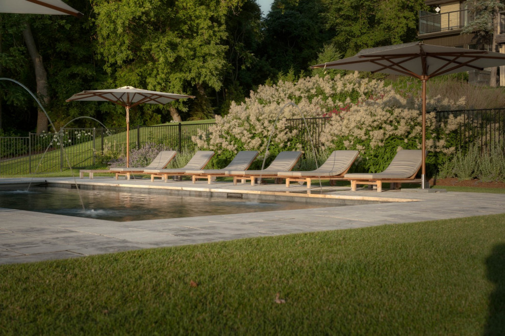 Großes Klassisches Sportbecken hinter dem Haus in rechteckiger Form mit Wasserspiel und Natursteinplatten in Toronto