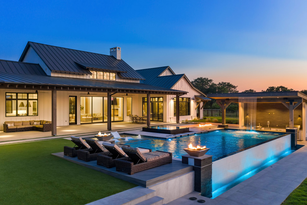 Großer Moderner Infinity-Pool hinter dem Haus in rechteckiger Form mit Dielen in Sonstige