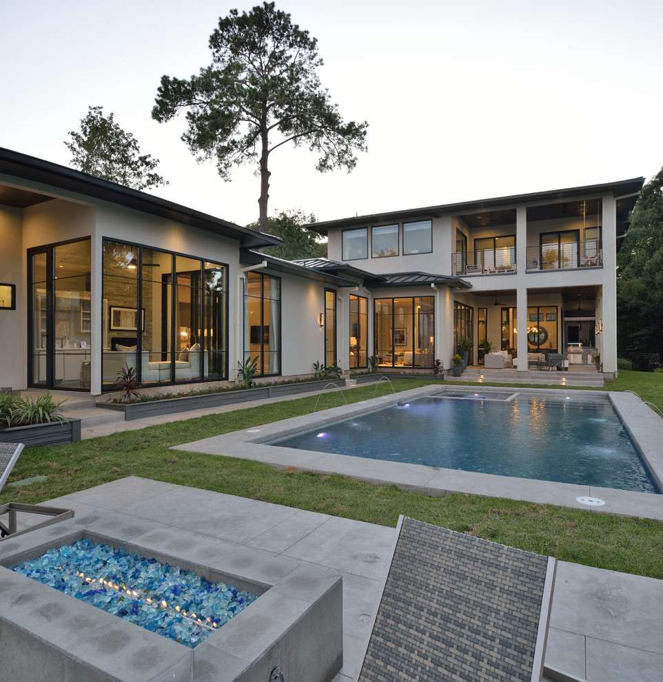 Großes Modernes Sportbecken hinter dem Haus in rechteckiger Form mit Wasserspiel und Betonplatten in Houston